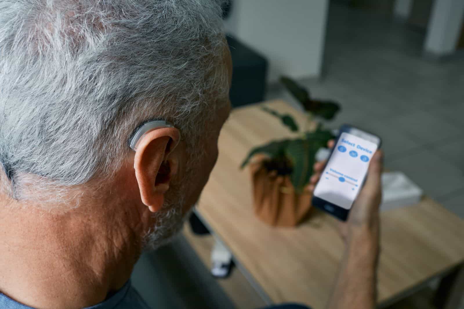 man with hearing aid using the hearing aid app