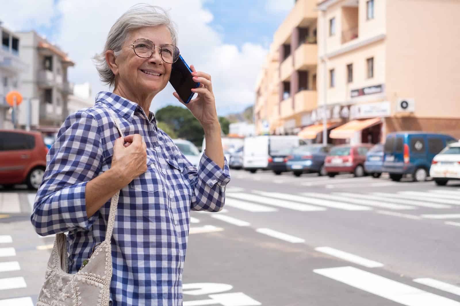 Senior woman on the phone crossing the road